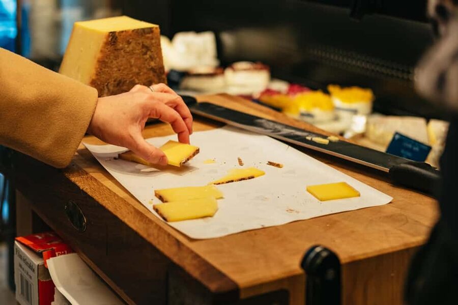 Paris: Gourmet Food Tour with Over 10 Tastings and Wine - Street-market atmosphere and a royal pastry connection